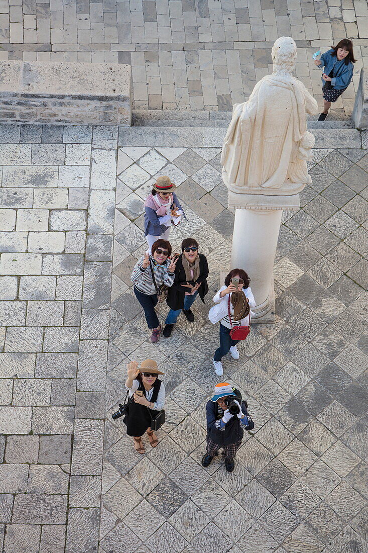 Overhead of Asian tourists in Old Town seen from bell tower of Cathedral of St. Lawrence, Trogir, Split-Dalmatia, Croatia
