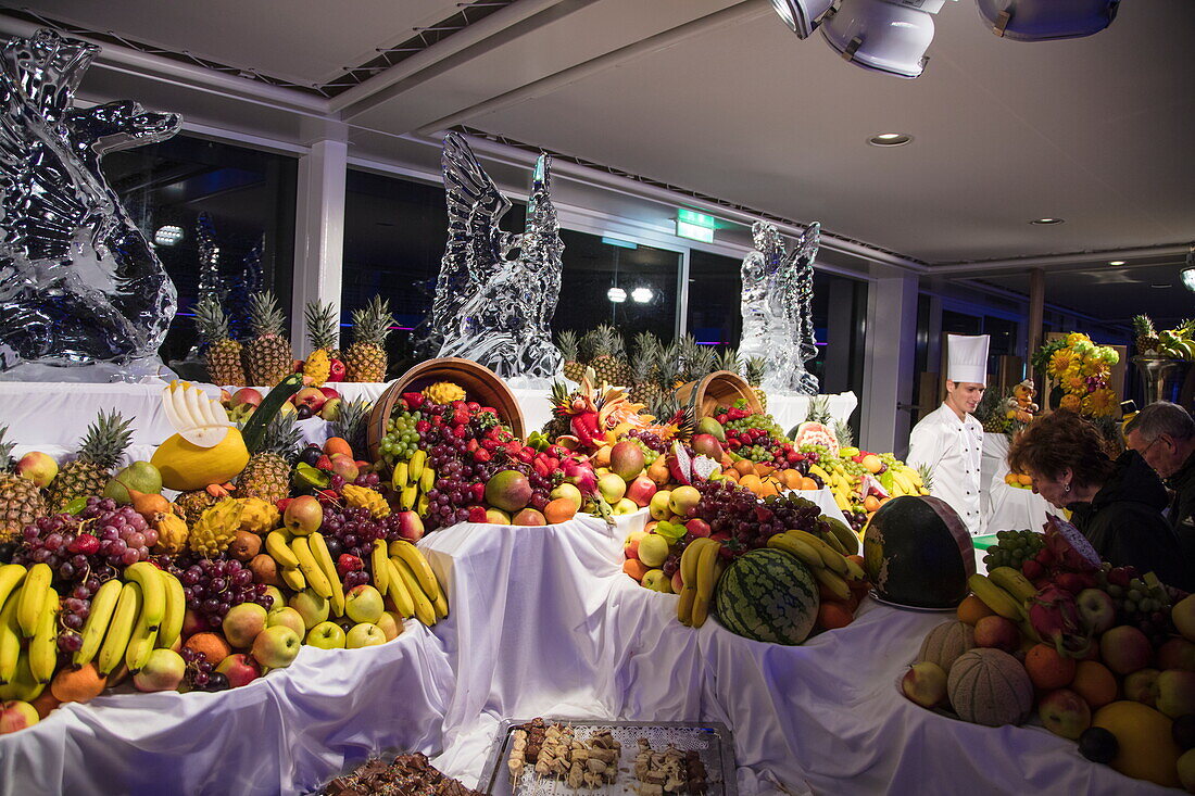 Fruit and chocolate buffet during pool party on Pooldeck of cruise ship Mein Schiff 6 (TUI Cruises) at night, Baltic Sea, near Denmark