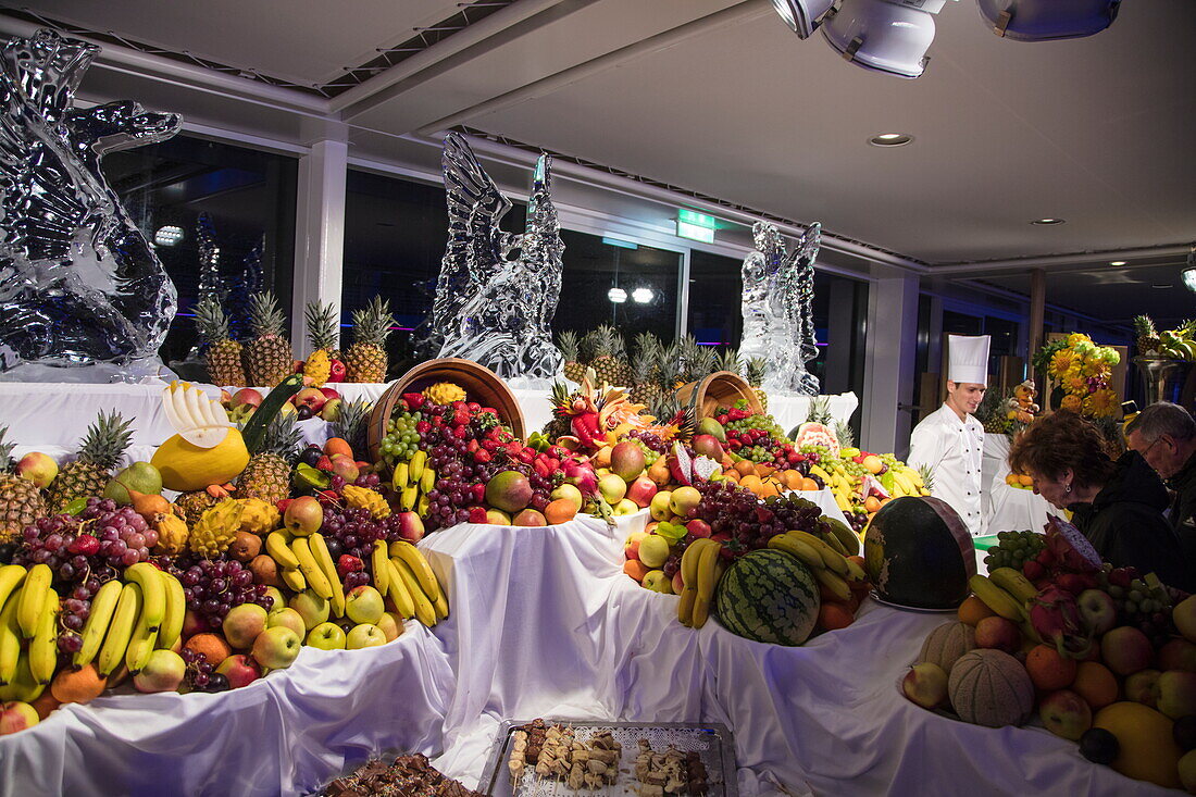 Obst- und Schokoladenbuffet bei Poolparty auf dem Pooldeck von Kreuzfahrtschiff Mein Schiff 6 (TUI Cruises) bei Nacht, Ostsee, nahe Dänemark, Europa