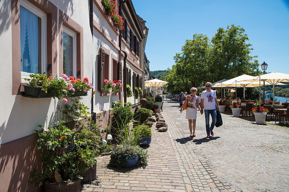 Couple strolls along Main river promenade, Marktheidenfeld, Spessart-Mainland, Franconia, Bavaria, Germany