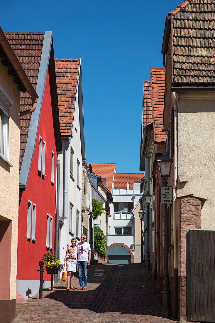 Couple strolls along alley in Old Town, Marktheidenfeld, Spessart-Mainland, Franconia, Bavaria, Germany
