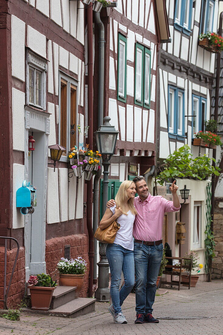 Couple enjoys stroll through Altstadt old town with half-timbered houses, Bad Orb, Spessart-Mainland, Hesse, Germany
