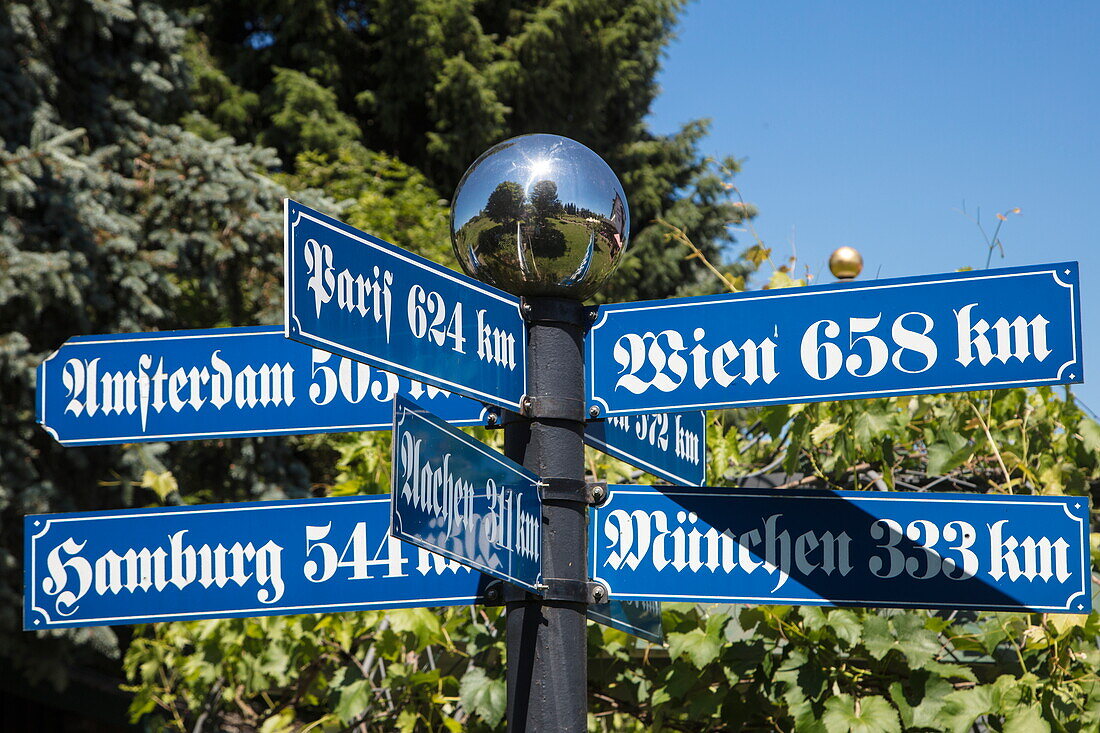 Distance signs in traditional Bavarian lettering in gardens of Hotel Brunnenhof, Weibersbrunn, Spessart-Mainland, Franconia, Bavaria, Germany