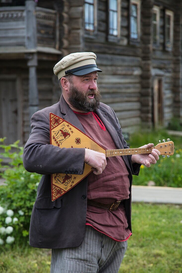 Mann spielt Balalaika im Museumsdorf Mandrogi am Fluss Swir, Mandrogi, Russland, Europa