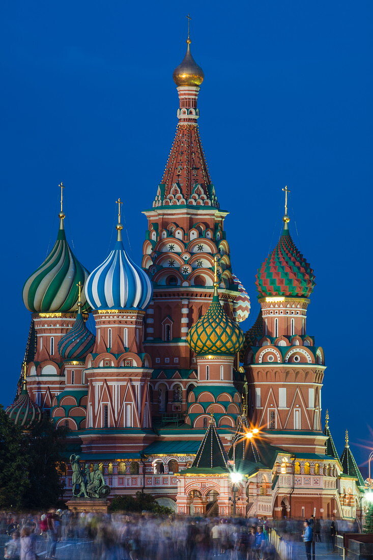 Menschen am Roten Platz und beleuchtete Basilius-Kathedrale in der Abenddämmerung, Moskau, Russland, Europa