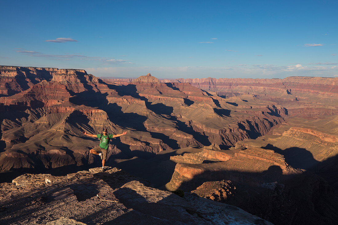 Man performs yoga at edge of Grand Canyon at Shoshone Point, Grand Canyon National Park, Arizona, USA