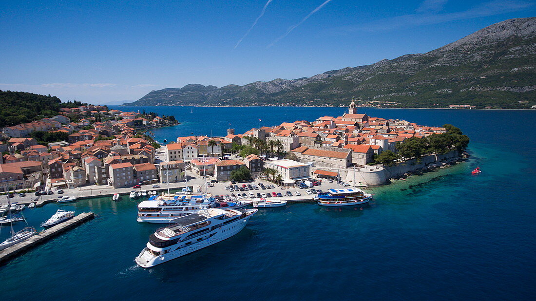 Luftaufnahme von Kreuzfahrtschiff MS Romantic Star (Reisebüro Mittelthurgau) welches sich Pier nähert mit Altstadt dahinter, Korcula, Dubrovnik-Neretva, Kroatien, Europa