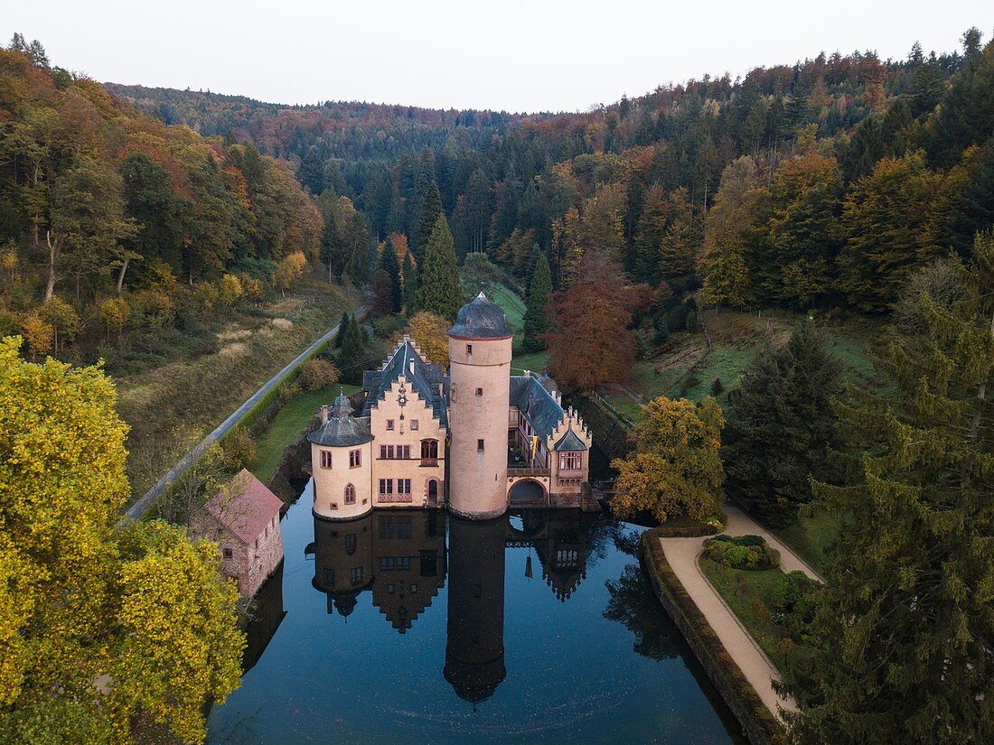 Aerial of Schloss Mespelbrunn castle with reflection in moat, Mespelbrunn, Räuberland, Spessart-Mainland, Bavaria, Germany