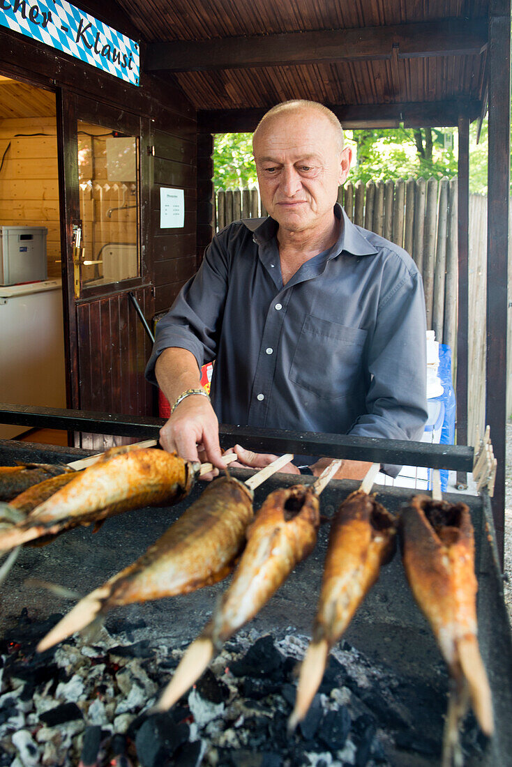 Streckerlfisch, grilled mackerel, are served in the beer garden at the Inselmühle in Munich, Bavaria