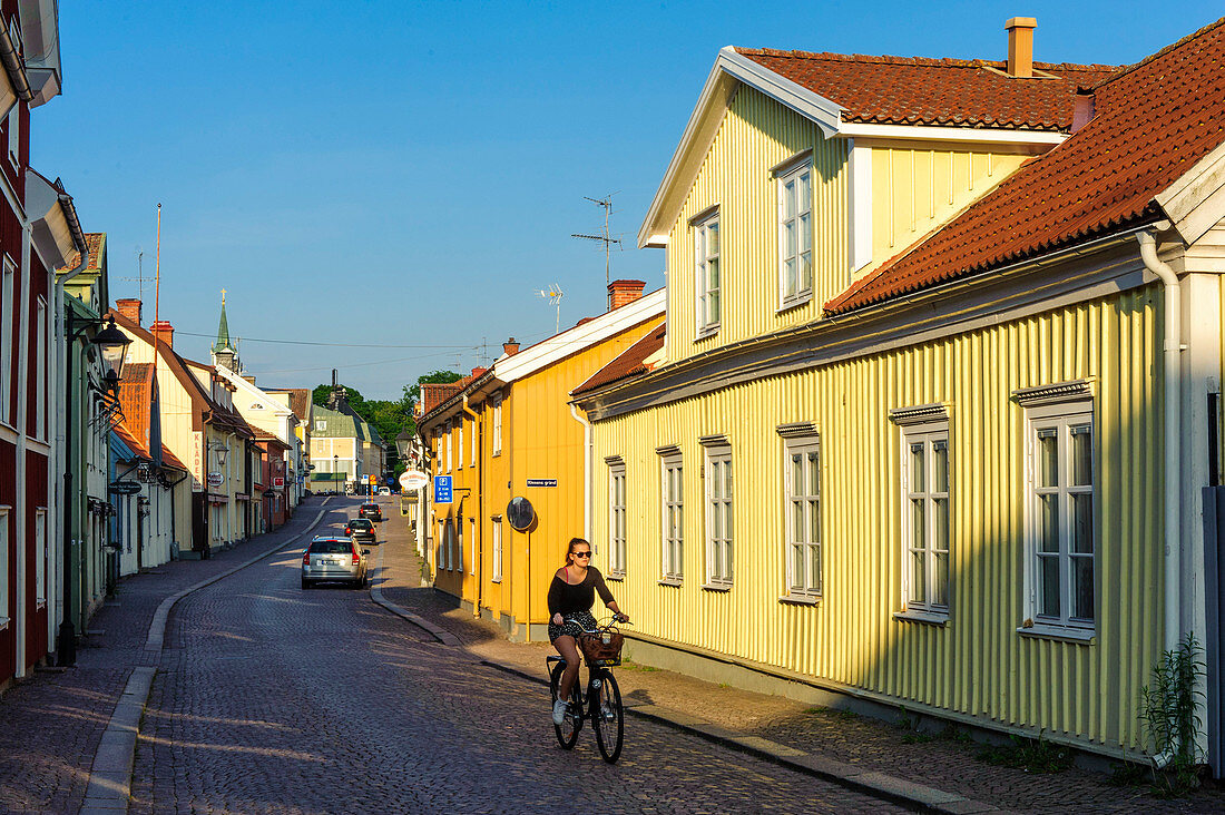 Young woman is cycling in alleys of Vimmerby, Sweden