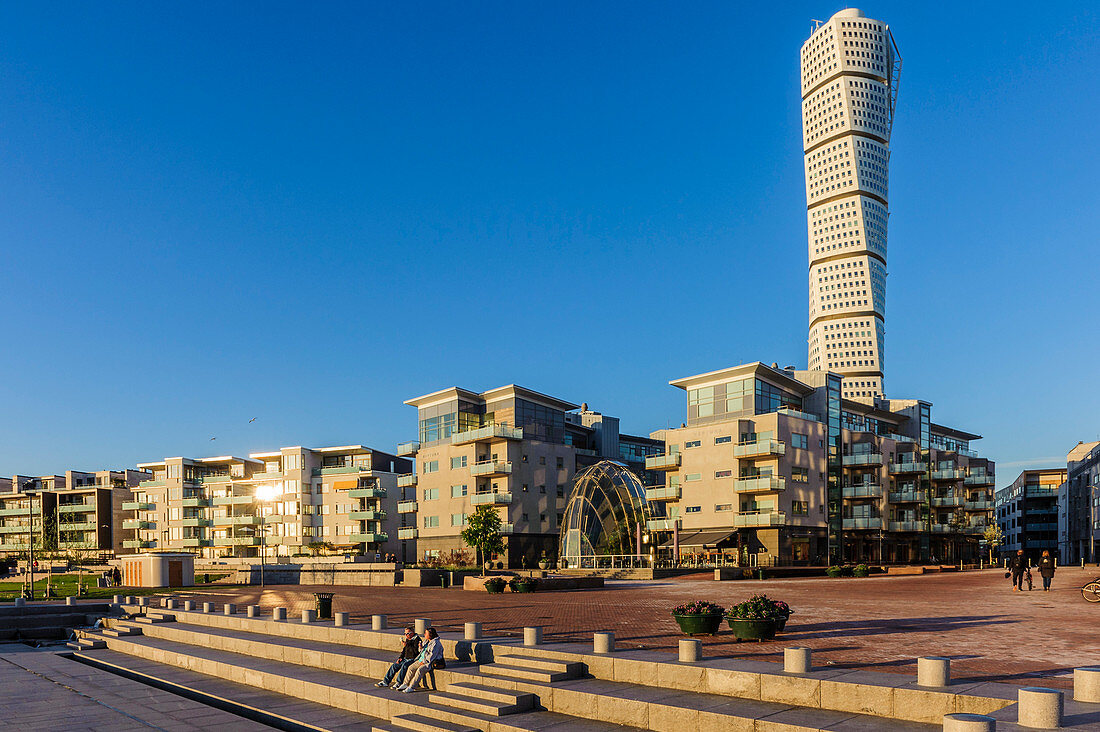 People sitting on a square, Turning torso in the rehabilitated harbor area, Malmo, Southern Sweden, Sweden