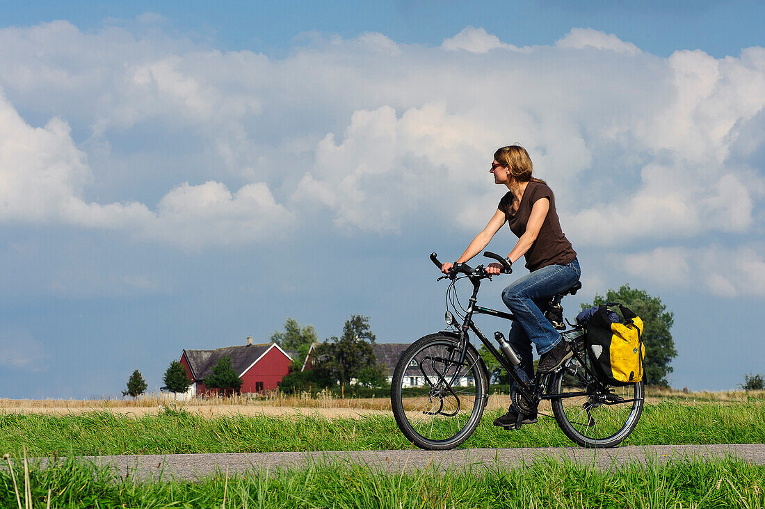 Woman on bicycle on the island of Ven, Skane, Southern Sweden, Sweden