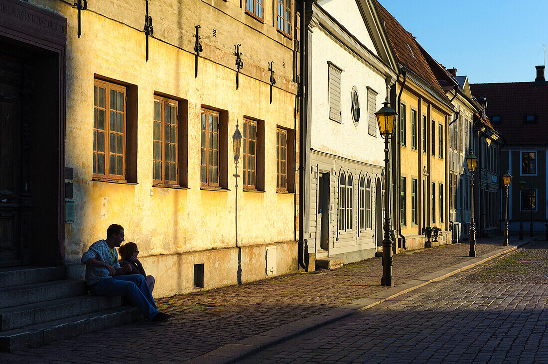 Stortorget in the evening light. Young people are sitting at the doorway, Schweden