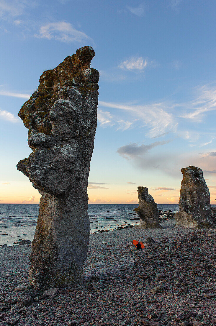 Rock coast Faroe called Raukar, Raukar are up to over 10 meters high limestone pillars found on Gotland / Faroe Island. Child with umbrella at the beach, Schweden