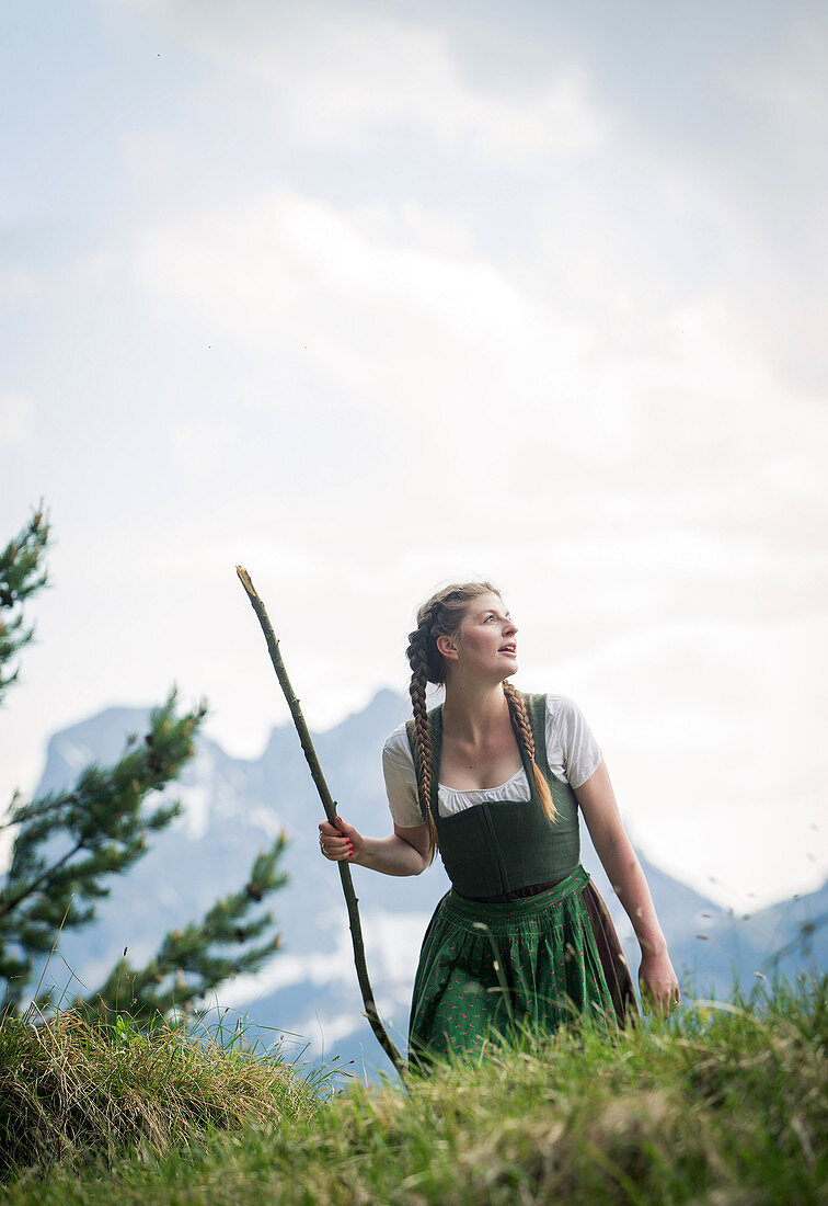 Young woman in traditional costume hiking on the Falkenstein in the Allgaeu, Pfronten, Bavaria, Germany