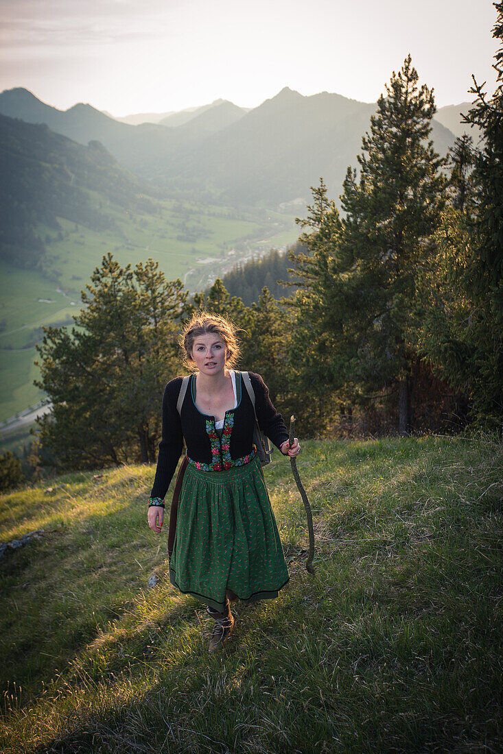 Junge Frau in Tracht wandert auf dem Falkenstein im Allgäu, Pfronten, Bayern, Deutschland
