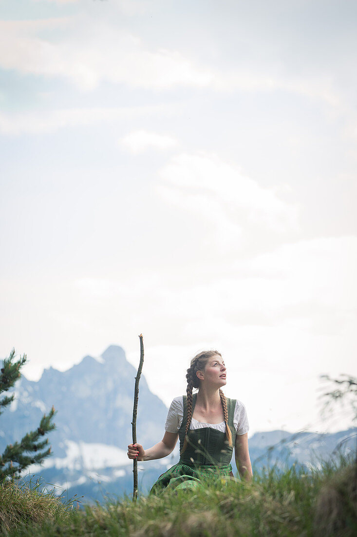 Young woman in traditional costume hiking on the Falkenstein in the Allgaeu, Pfronten, Bavaria, Germany