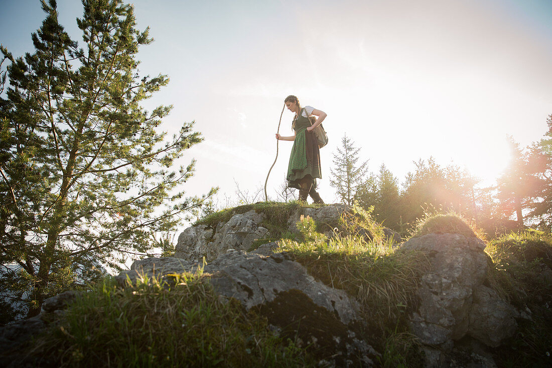 Young woman in traditional costume hiking on the Falkenstein in the Allgaeu, Pfronten, Bavaria, Germany