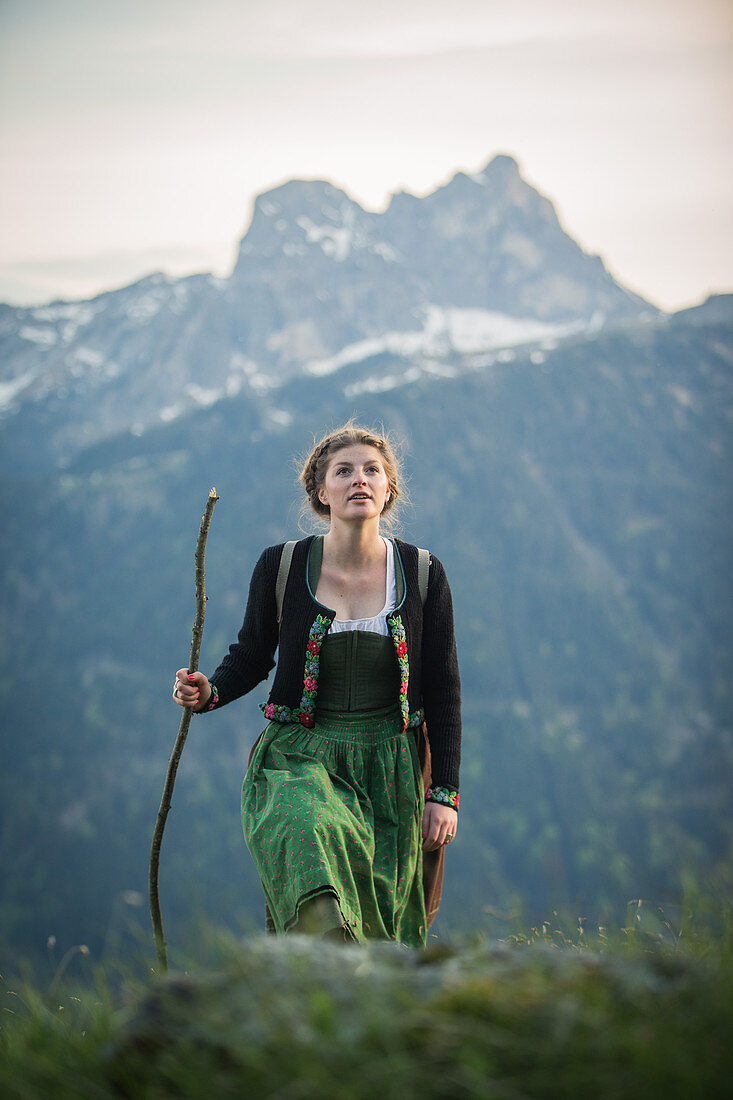 Junge Frau in Tracht wandert auf dem Falkenstein im Allgäu, Pfronten, Bayern, Deutschland