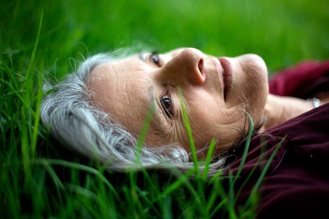 Pensive Caucasian woman laying in grass