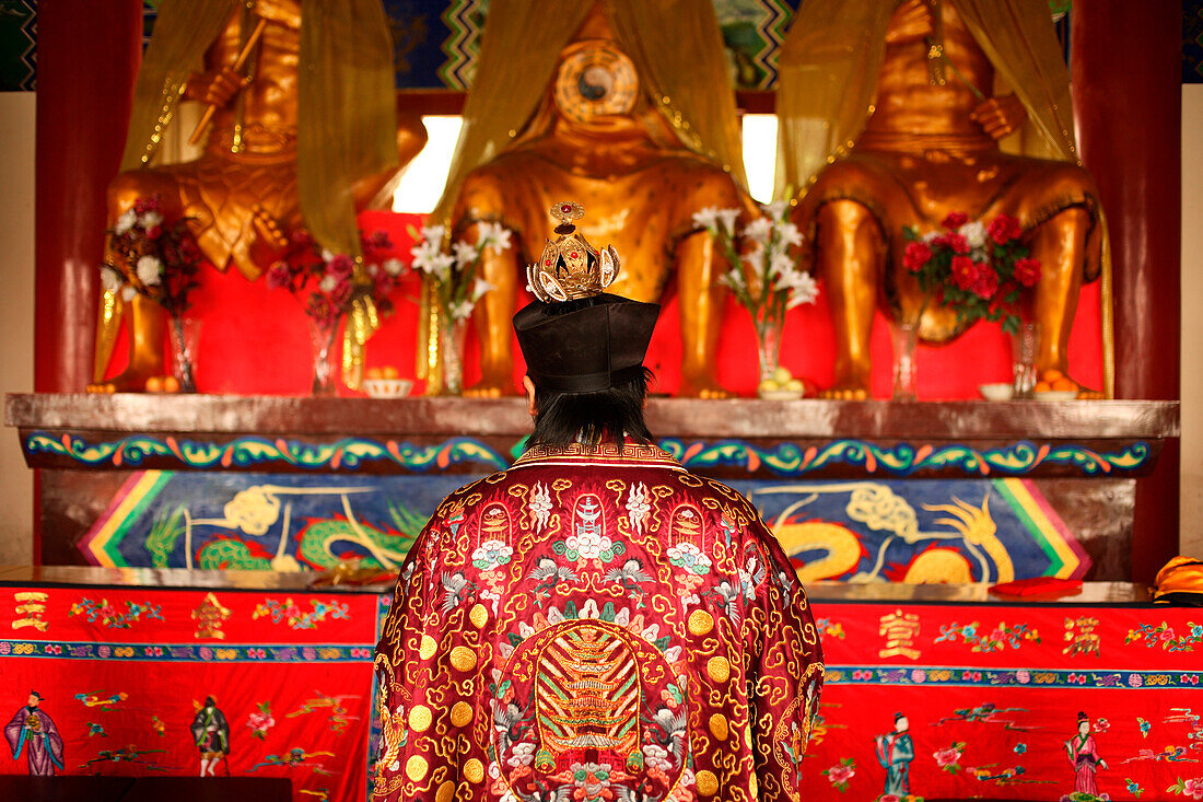 Person wearing ornate robe in temple