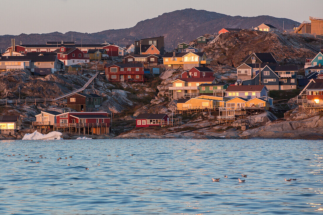 colorful houses along the fjord at sunset, ilulissat, greenland