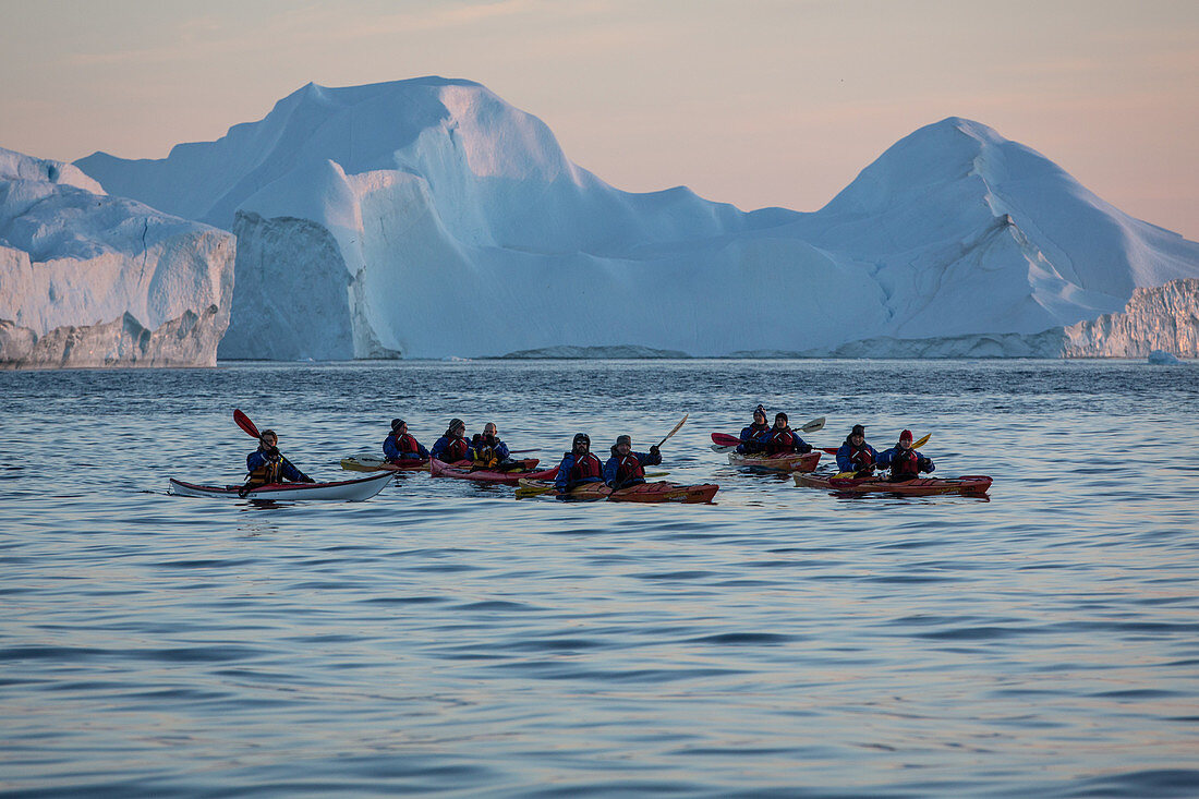 kayaking at nightfall in front of the icebergs in the ice fjord, jakobshavn glacier, 65 kilometres long, coming from the inlandsis, sermeq kujalleq, ilulissat, greenland