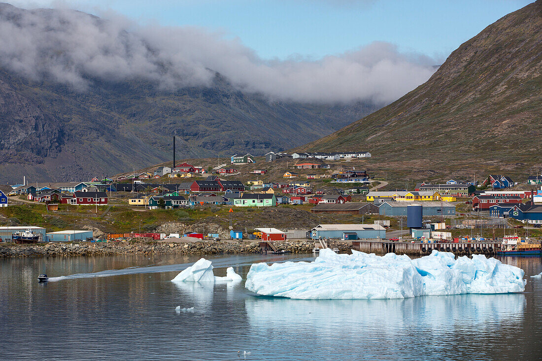 icebergs in front of the little town of colorful wooden houses at the foot of the mountain, narsaq, greenland