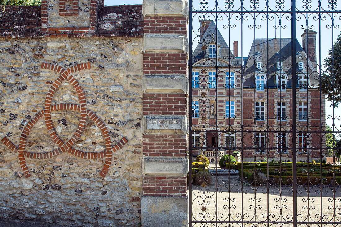 outer wall with the three entwined crescents, the emblem of king henri ii, and the facade of the grand chateau of menilles (27), france