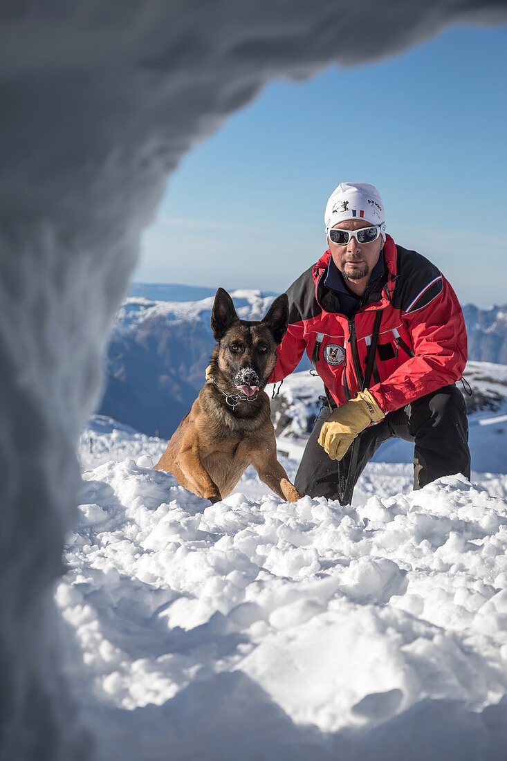 jean-michel morlot and his belgian malinois named jeep in front of an opening in the snow looking for a victim, reporting on avalanche dog handlers, training organized by the anena with the approval of the civil security department, les-2-alpes (38), fran