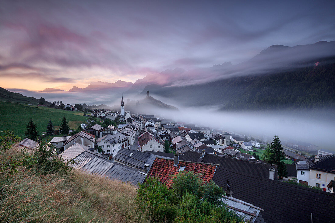 Pink clouds and mist on the village of Ardez at dawn, district of Inn, Lower Engadine, Canton of Graubunden, Switzerland, Europe