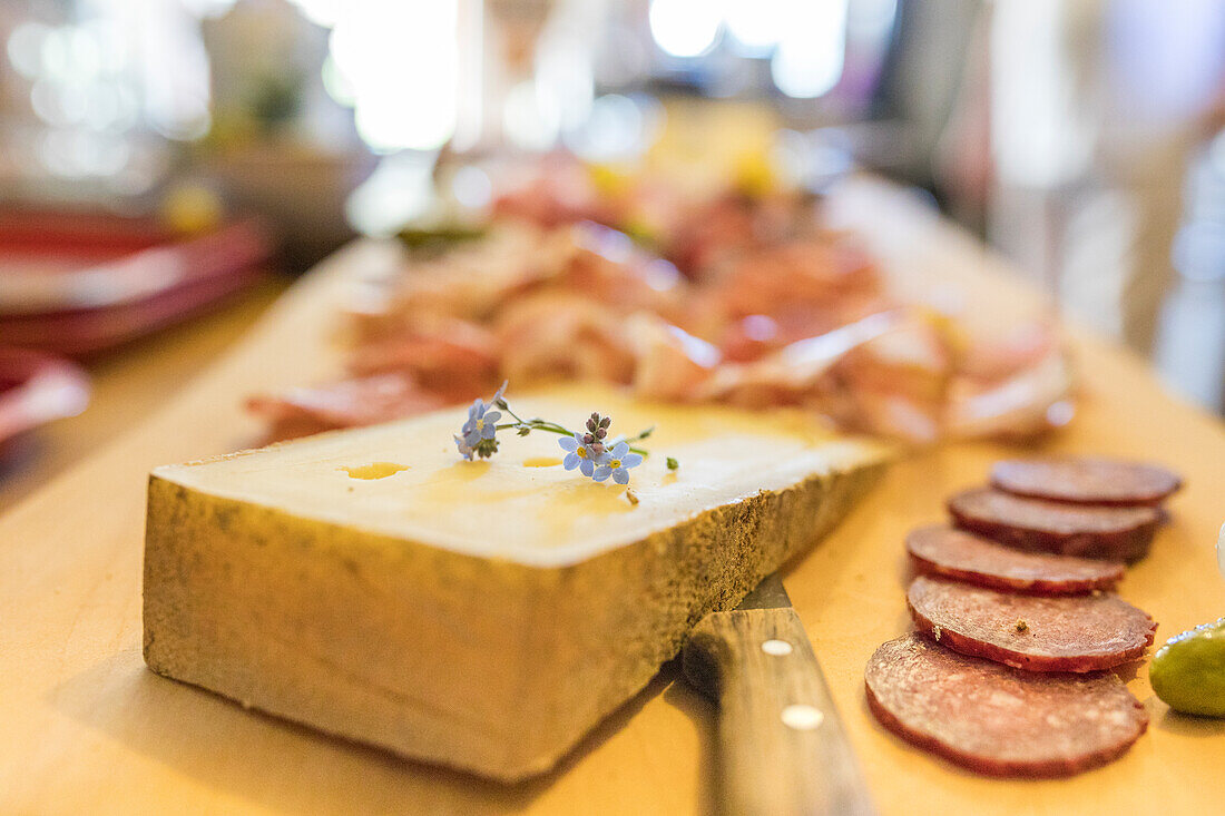 Typical salami and cheese on chopping board, San Romerio Alp, Brusio, Canton of Graubunden, Poschiavo Valley, Switzerland, Europe