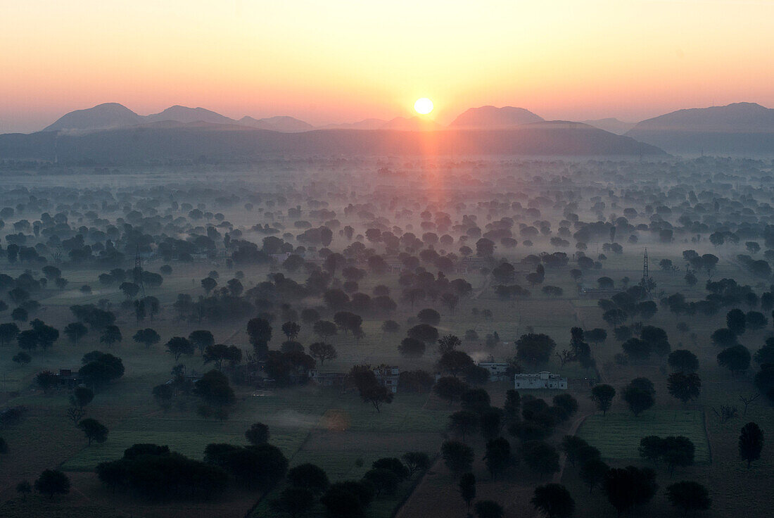 Sun rising over the hills and countryside surrounding Samode, from hot air balloon, Rajasthan, India, Asia