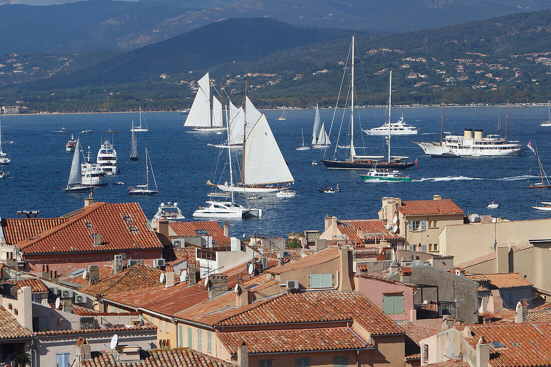 France, Var department, a large view on the old roofs of the city of Saint-Tropez with in background yachting boats