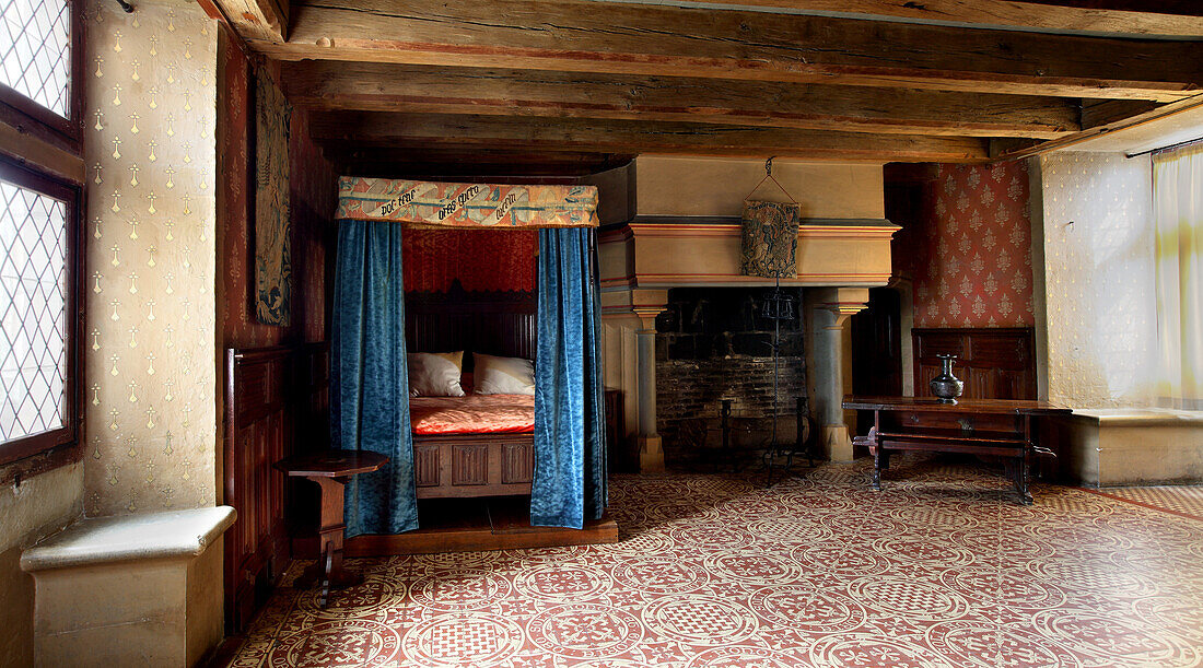 France, Centre France, Touraine, Chateau feodal de Langeais. The crucifixion bedroom with its old bed and chimney.