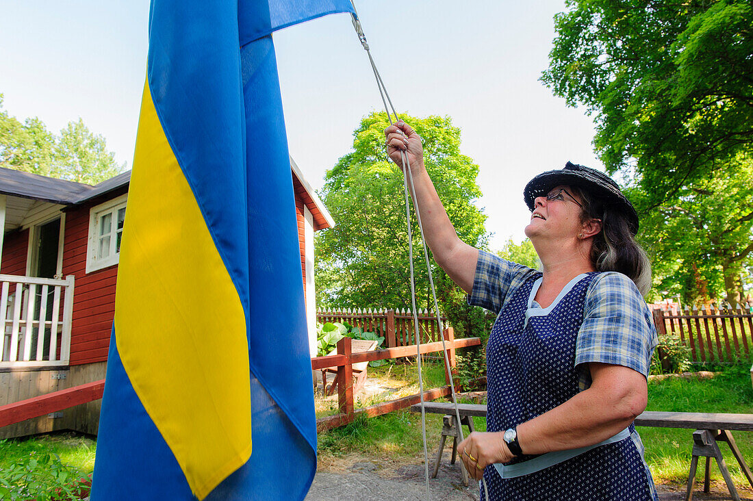schwedischer Schrebergarten im Freiluftmuseum Skansen, die schwedische Flagge wird eingeholt , Stockholm, Schweden