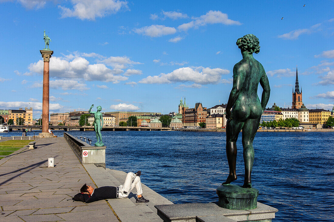 Man enjoys the sun Stadshuset Rathaus garden, Stockholm, Sweden