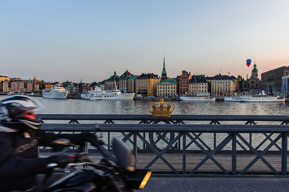 Motorcycle on the Skeppsholmsbron with crown on the railing on the old town, Stockholm, Sweden