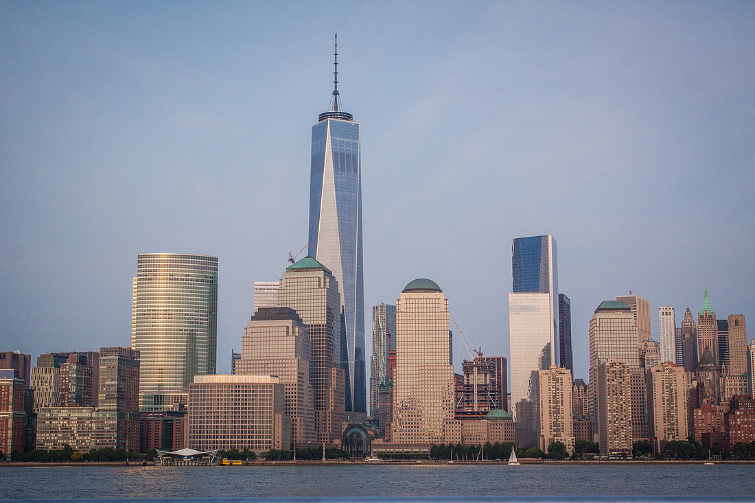 sun setting over the skyline of the financial district of new york with one world trade center dominating the cityscape, view from jersey city, manhattan, new york city, state of new york, united states, usa