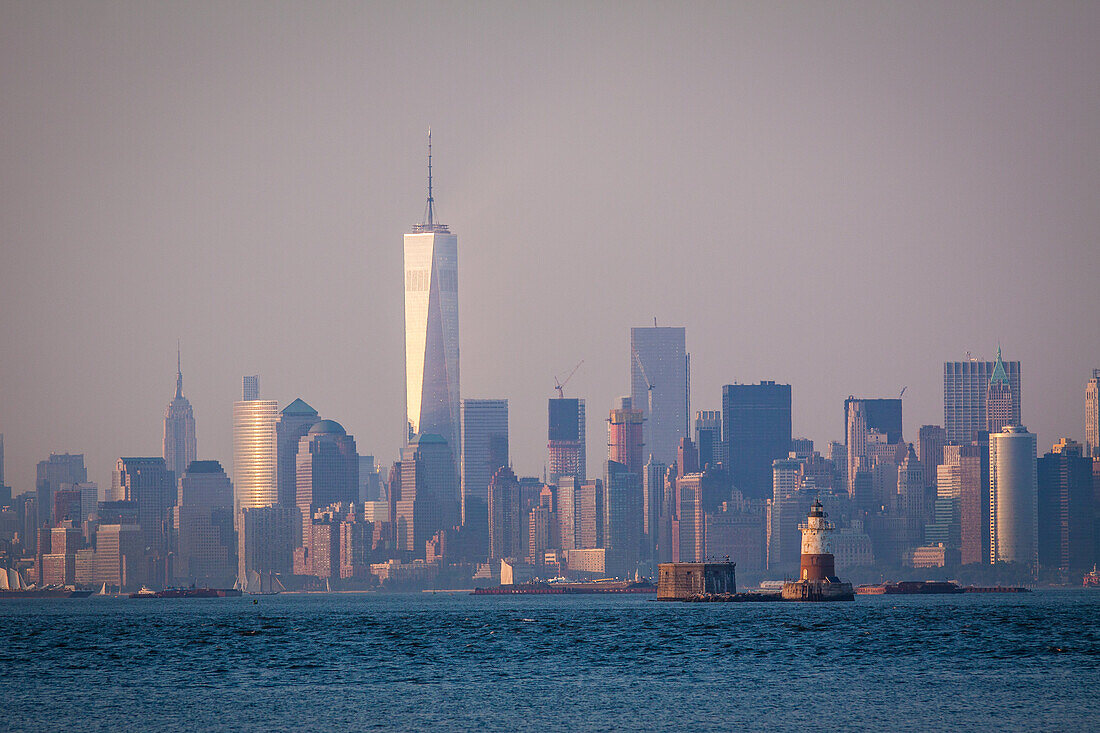 sun setting over one world trade center and the manhattan skyline as seen from the saint george ferry terminal of staten island, new york harbor, manhattan, new york city, state of new york, united states, usa