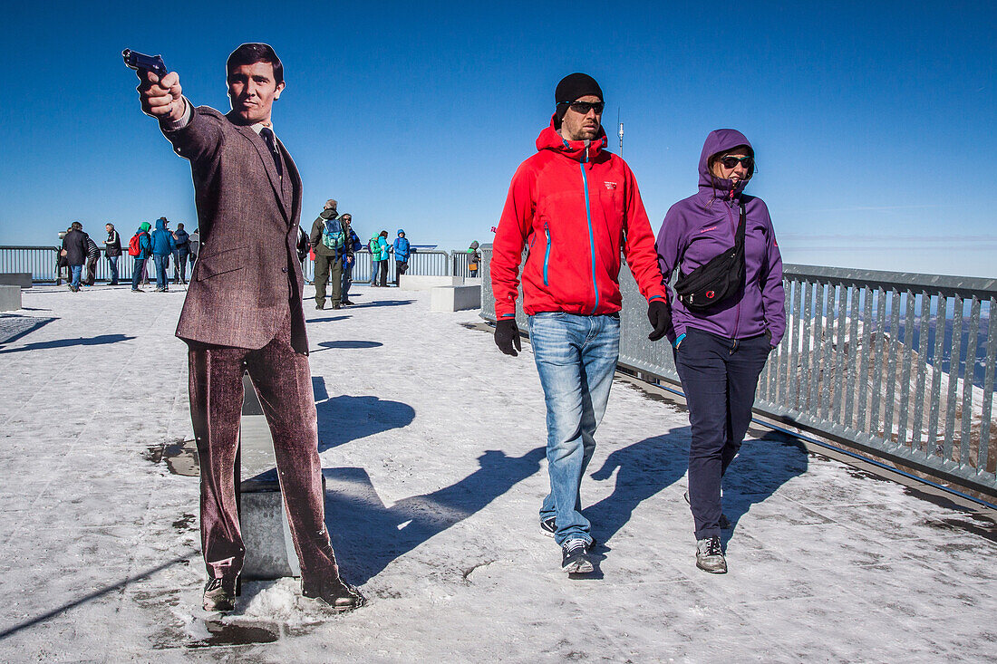 tourist passing next to a life-size effigy of george lazenby who played the secret agent james bond 007 in the film on her majesty's secret service, terrace of the restaurant at the summit of the schiltorn, the place where the film on her majesty's secret