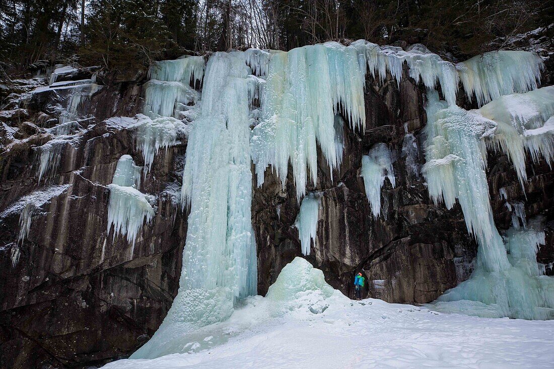 climber/mountaineer contemplating the ice cascades on a rocky cliff face, golsjuvet falls, gol, region of buskerud, norway