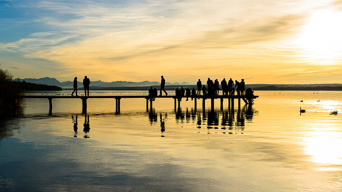 romantic sunset on the jetty with mountainview, lake Ammersee, Bavaria, Germany