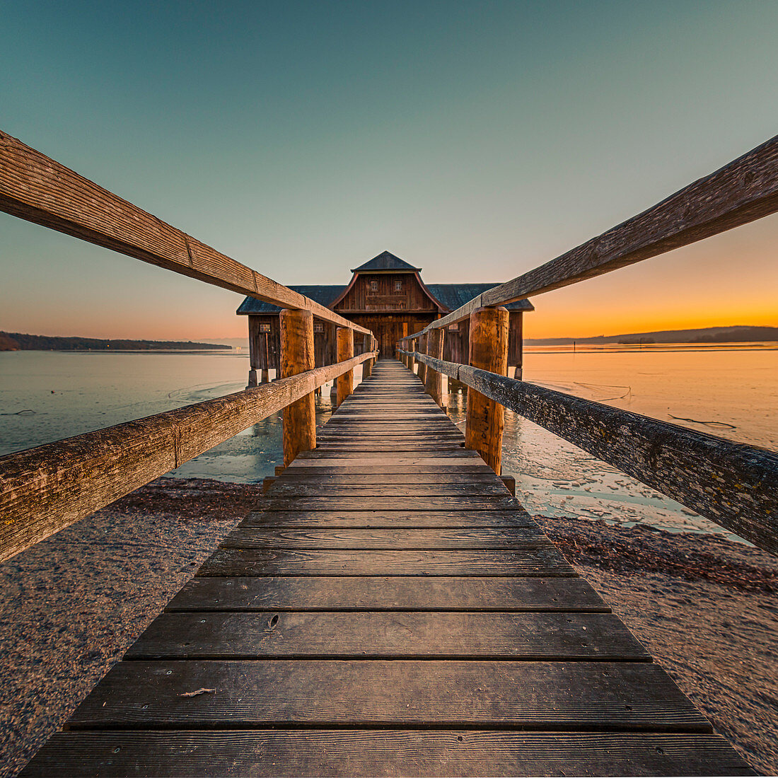 on the jetty to the boathouse during a romantic sunset, Stegen, Bavaria, Germany