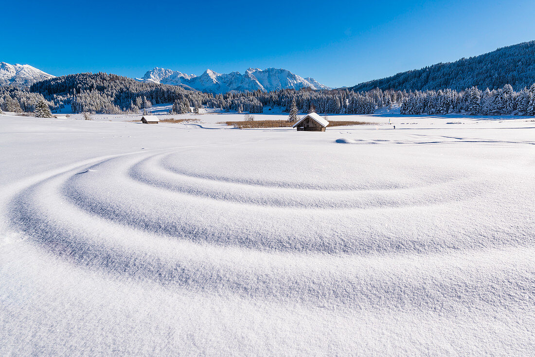 Wellen im frischen Schnee am Wagenbrüchsee, Bayern, Deutschland
