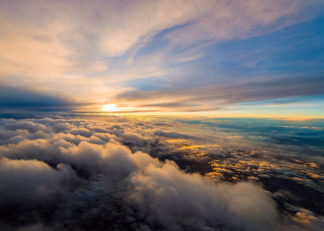 Traumhafter Sonnenuntergang bei einem Flug zwischen zwei Wolkenschichten