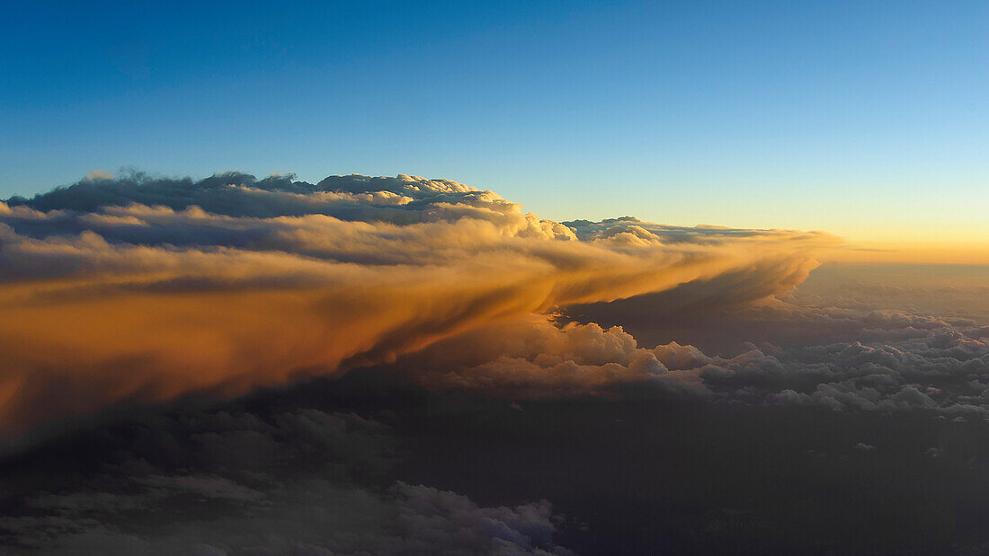 Das warme Licht am Abend strahlt einen Wolkenturm über der Schweiz an