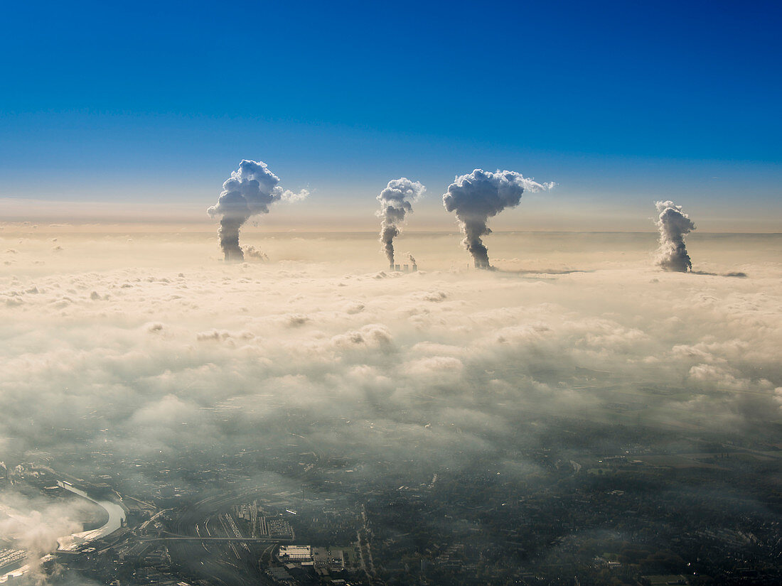 Wasserdampf aus den  Kühltürmen der Kraftwerke bei Grevenbroich in der Nähe von Düsseldorf durchstossen den Nebel am Morgen, Nordrhein-Westfalen, Deutschland