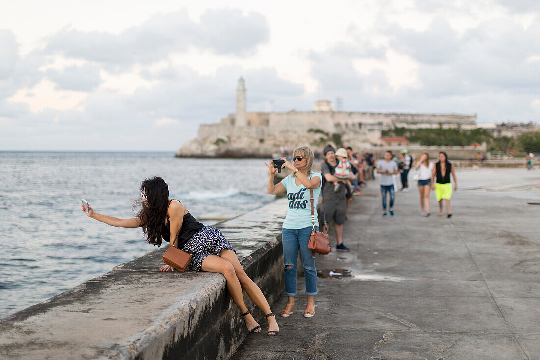tourists and local people and fisherman at Malecon, historic town center, old town, Habana Vieja, Habana Centro, opposite Castillo De Los Tres Reyes Del Morro, family travel to Cuba, holiday, time-out, adventure, Havana, Cuba, Caribbean island