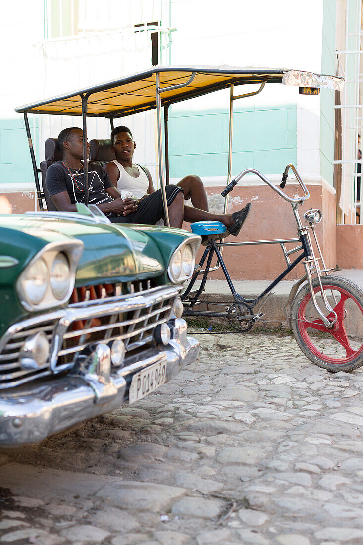 bicycle rickshaw, young cool boys taking a rest, oldtimer, center of the city, family travel to Cuba, parental leave, holiday, time-out, adventure, Trinidad, province Sancti Spiritus, Cuba, Caribbean island
